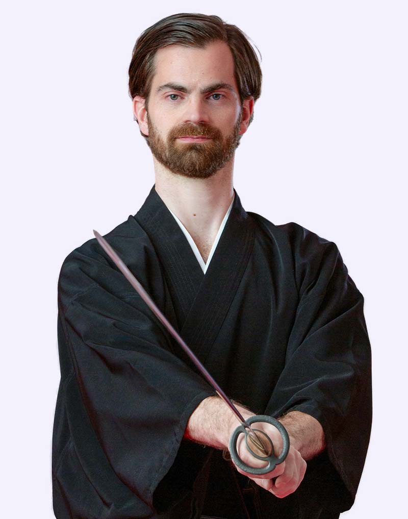 Dr. Gert Jungbauer MSc. mit Katana in traditioneller Kampfkunstpose – japanische Werte wie Präzision, Disziplin und Achtsamkeit als Leitprinzipien seiner zahnärztlichen Praxis