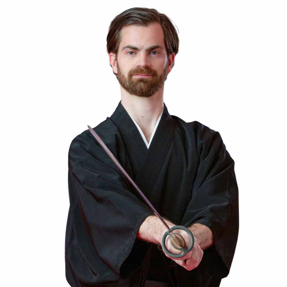 Dr. Gert Jungbauer MSc. in traditioneller Pose beim japanischen Schwertkampf – Symbol für Präzision und Disziplin in der Zahnmedizin